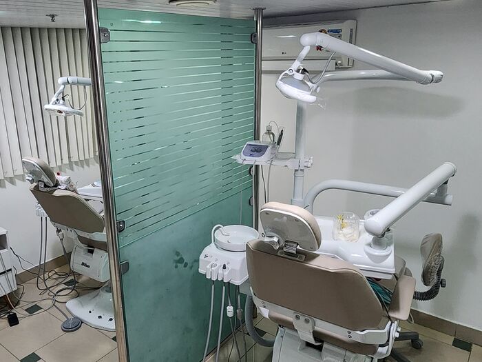 Sala de atendimento com duas cadeiras odontológicas separadas por um painel de vidro jateado