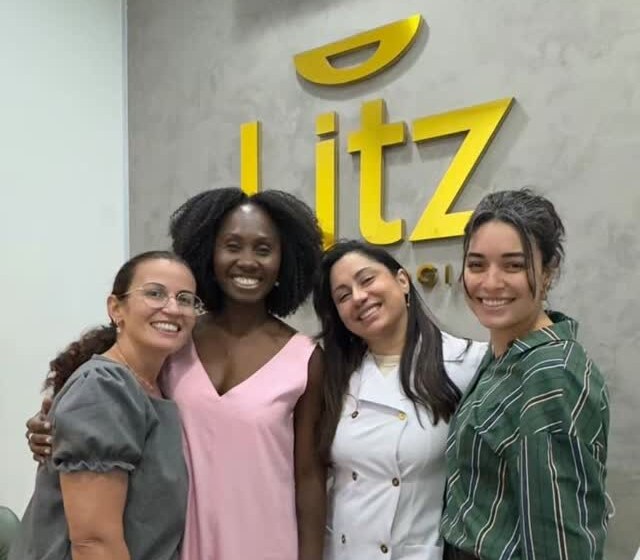A equipe Litz sorrindo junta em frente ao letreiro da clínica